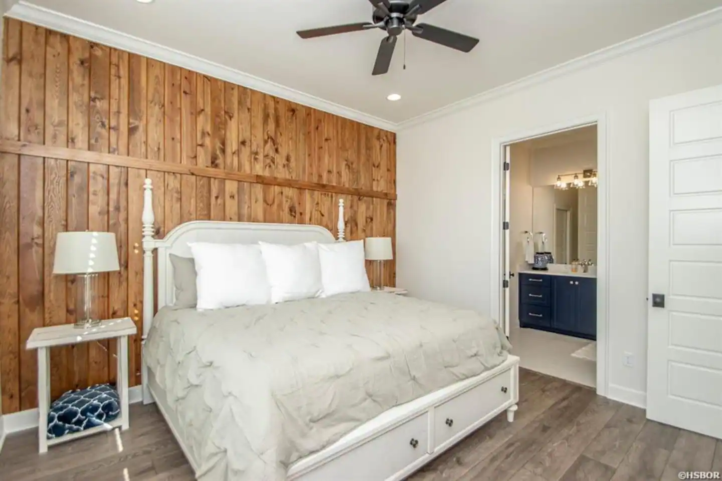 A bedroom with a king size bed and a ceiling fan.