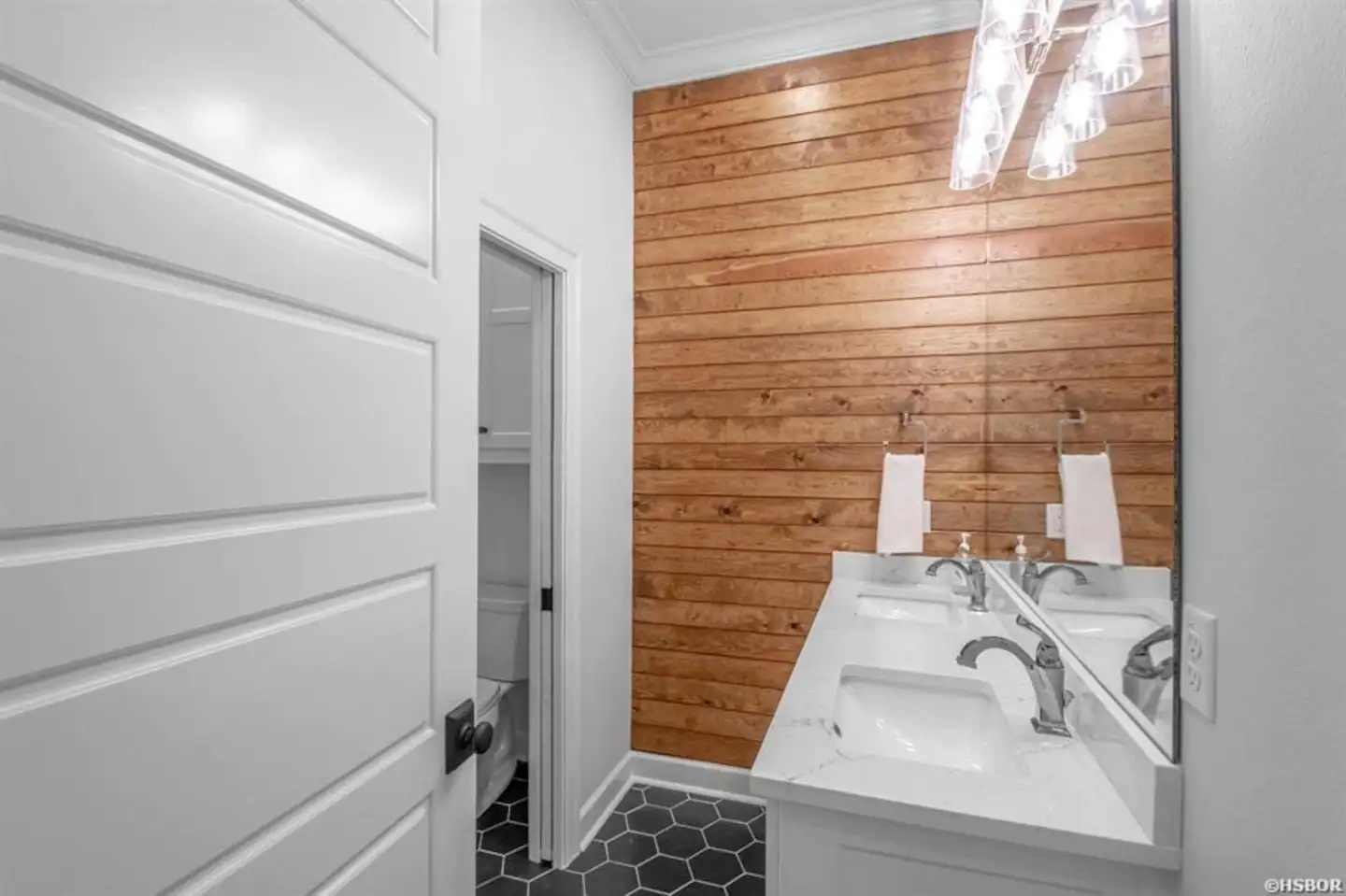 A bathroom with two sinks and a large mirror.