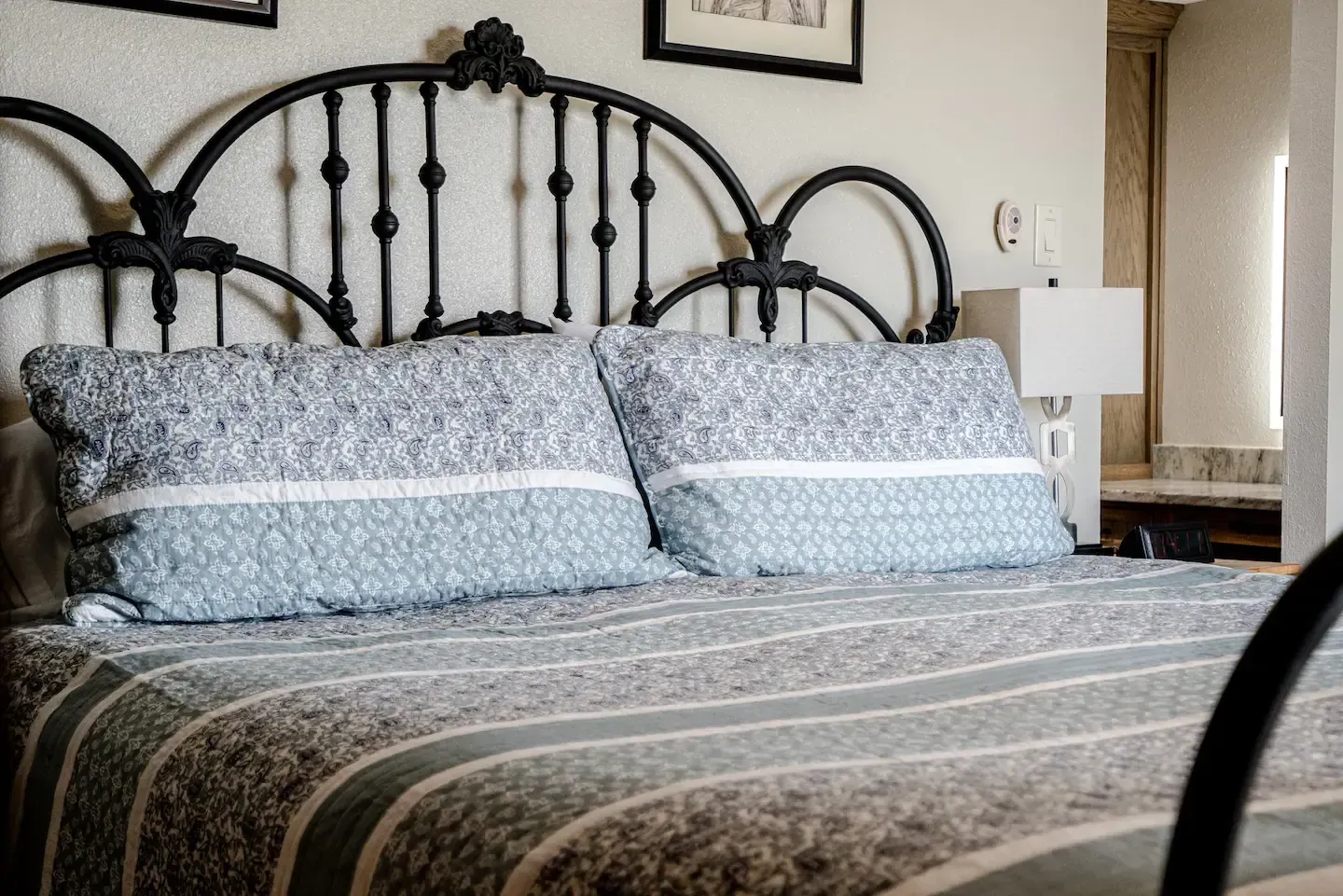 A bed with two pillows and a black headboard in a bedroom.