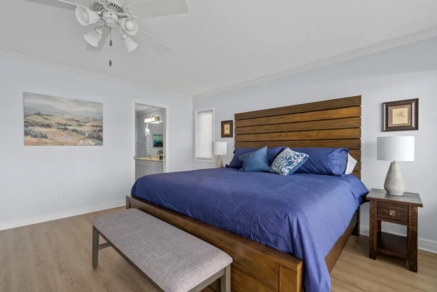A bedroom with a king size bed and a bench.