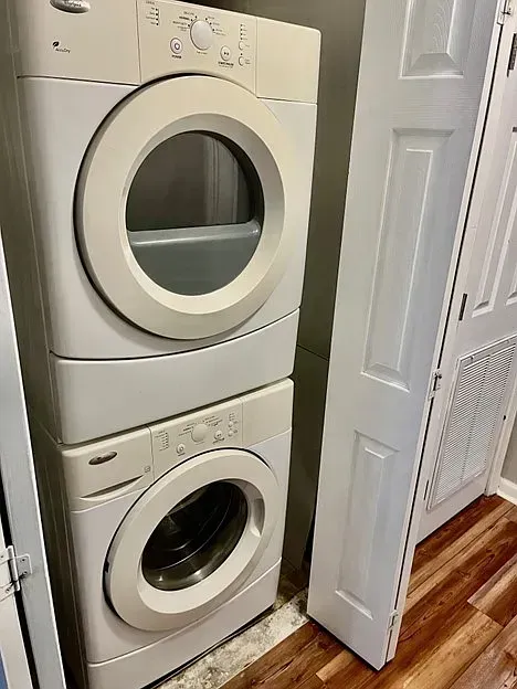 A washer and dryer are stacked on top of each other in a laundry room.