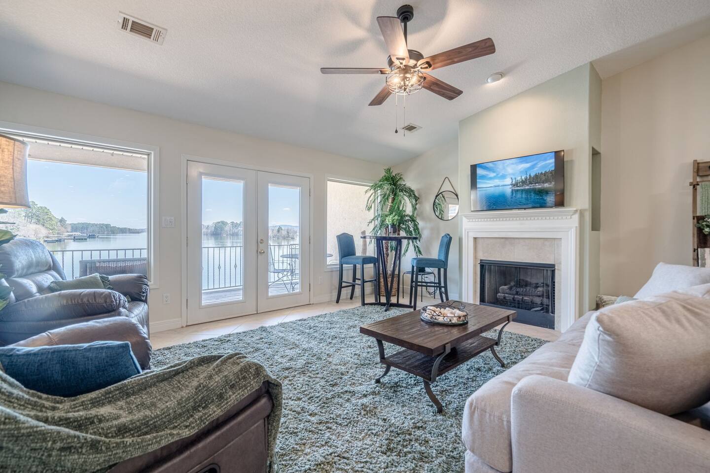 A living room with a couch , chairs , coffee table , fireplace and television.