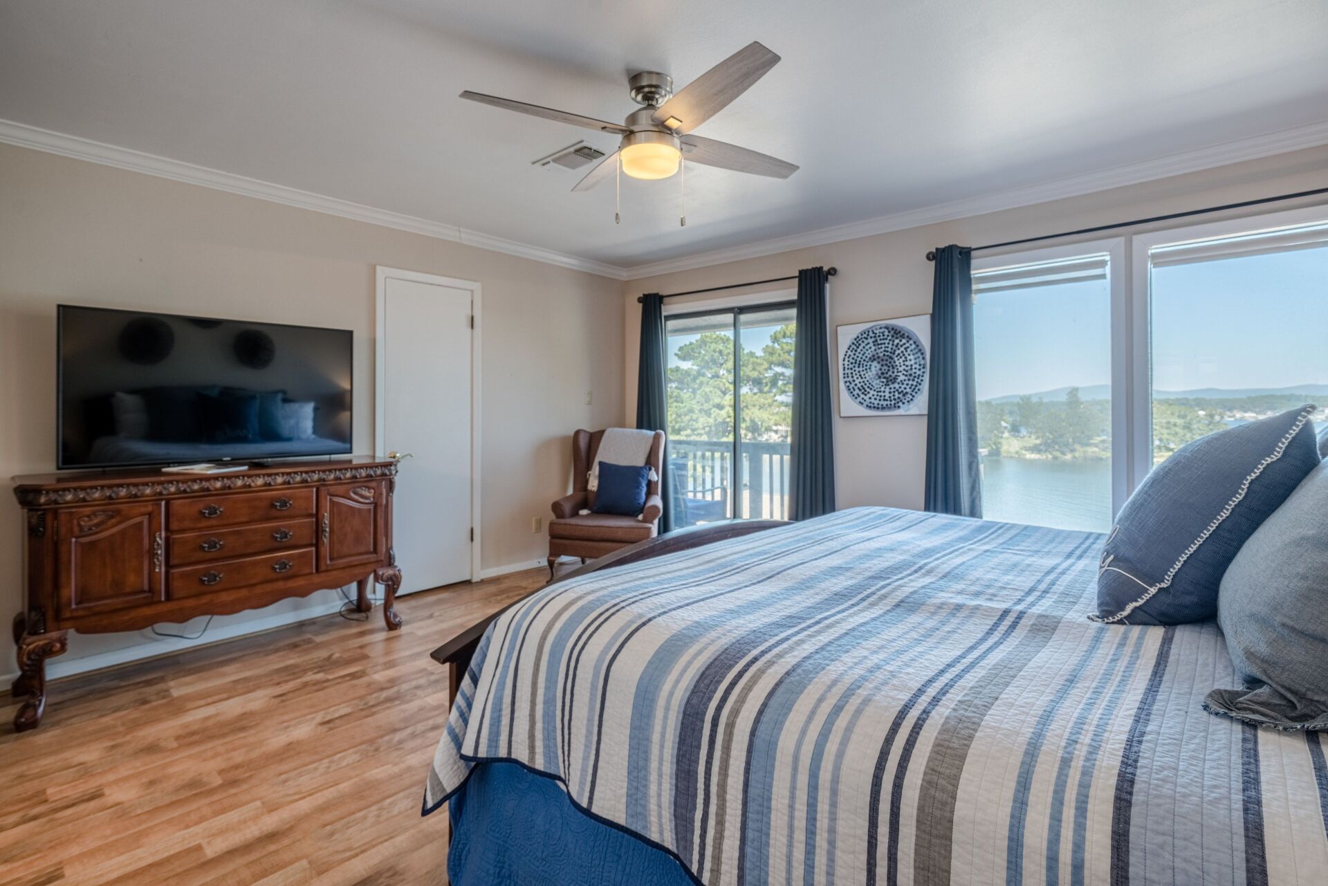 A bedroom with a king size bed , television , and sliding glass doors.
