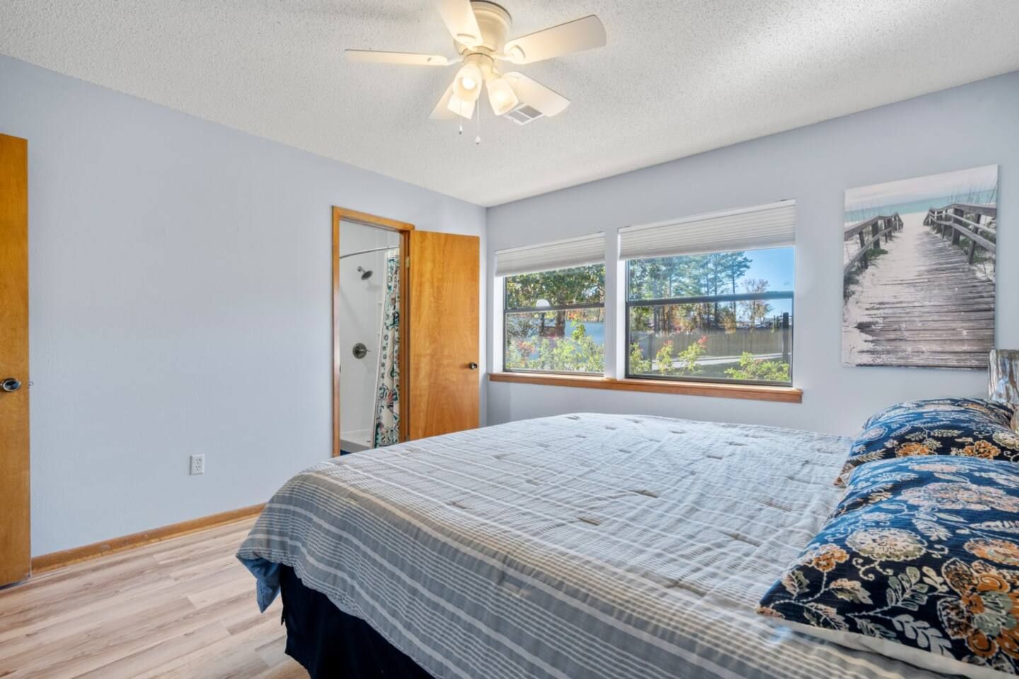 A bedroom with a large bed and a ceiling fan.