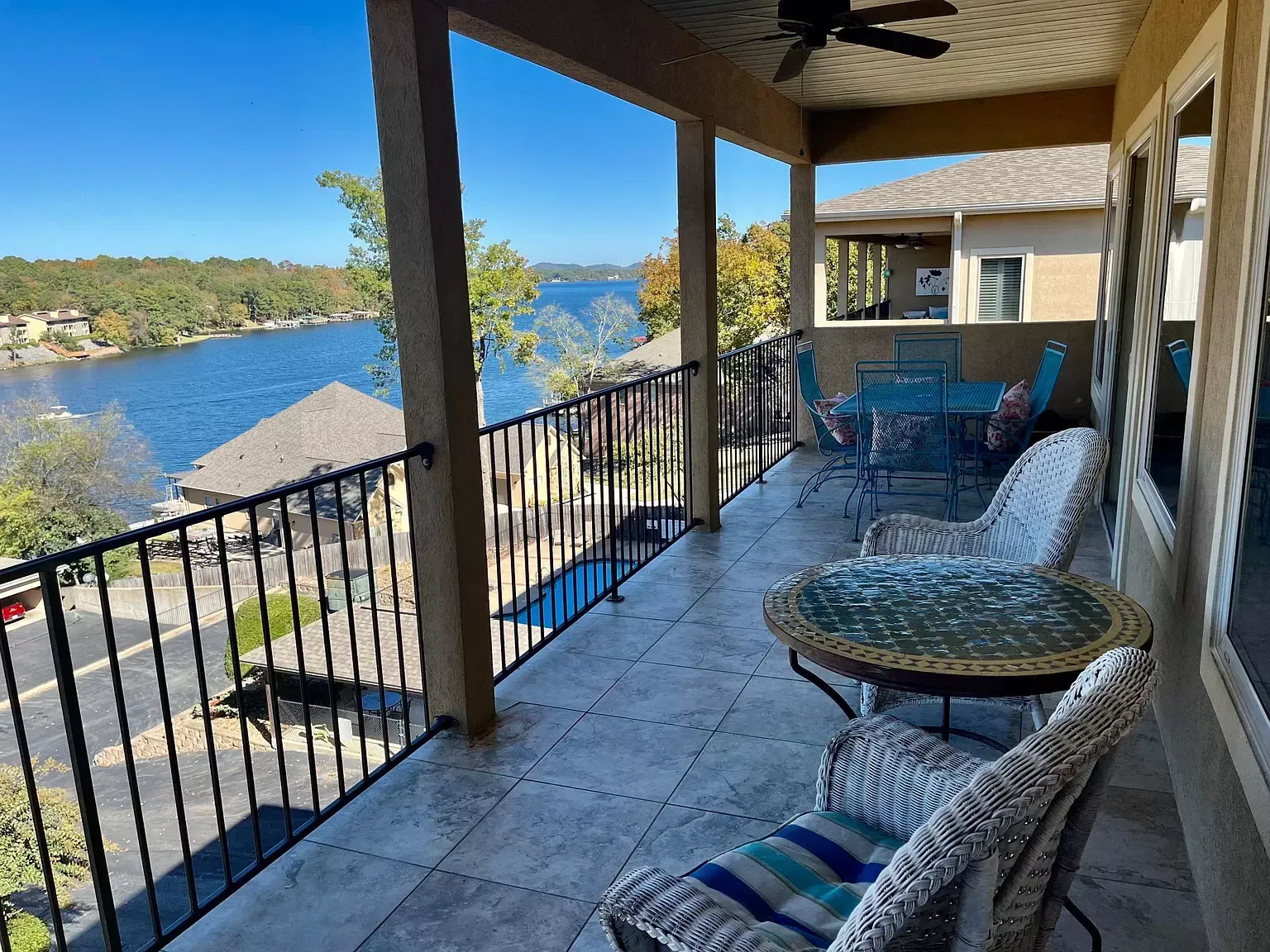 A balcony with a table and chairs overlooking a lake.