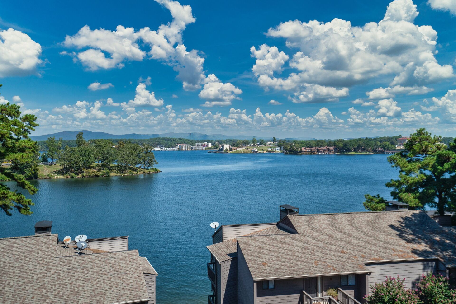 An aerial view of a lake with a house in the foreground