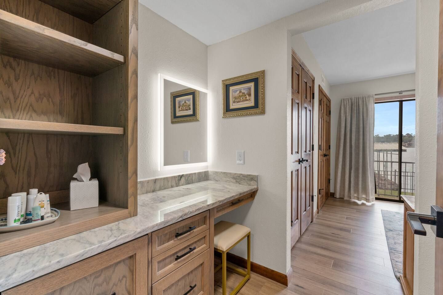 A bathroom with a vanity , mirror and sliding glass door.