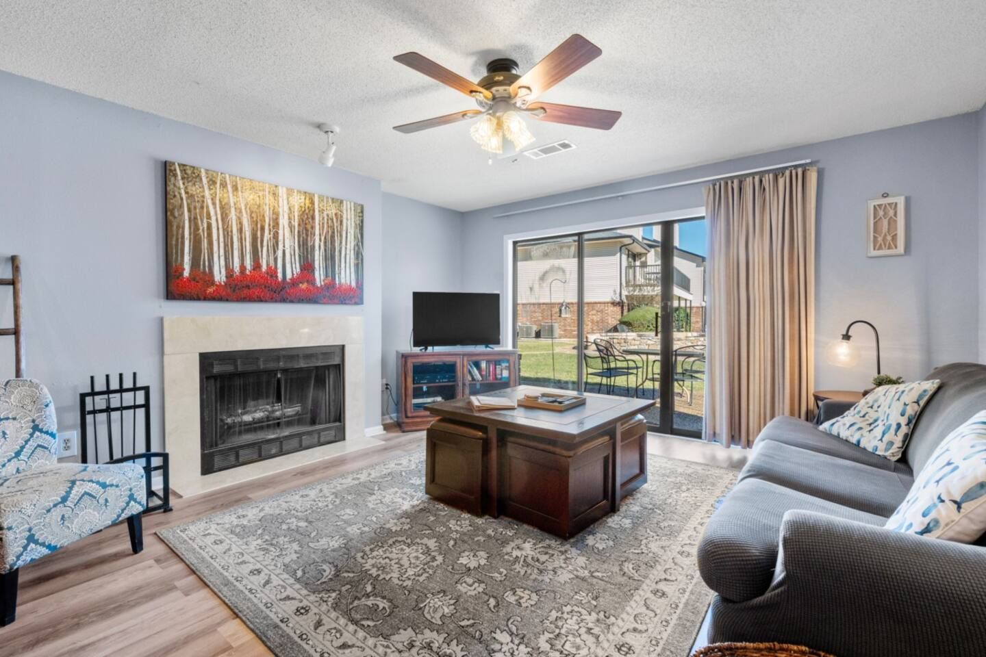 A living room with a couch , fireplace , coffee table and television.