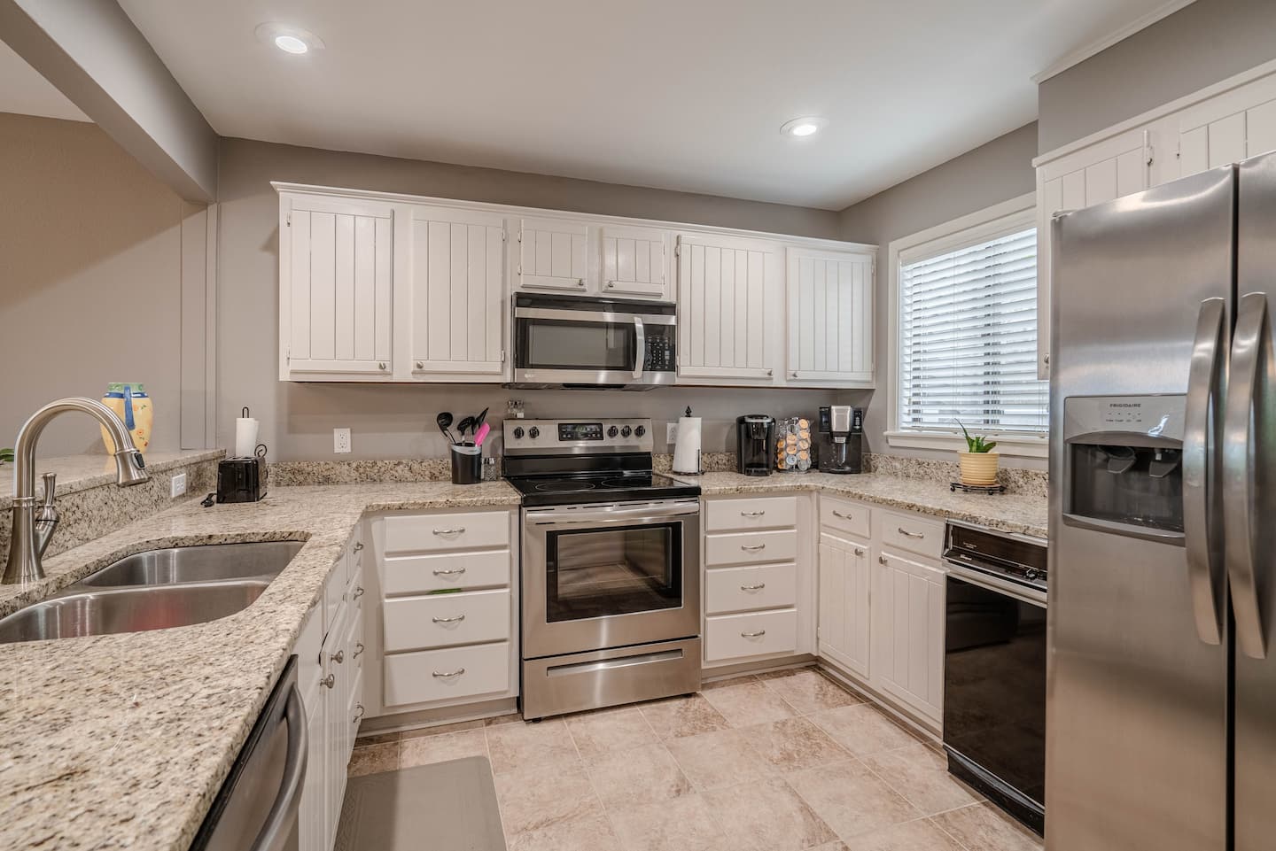 A kitchen with stainless steel appliances and granite counter tops.