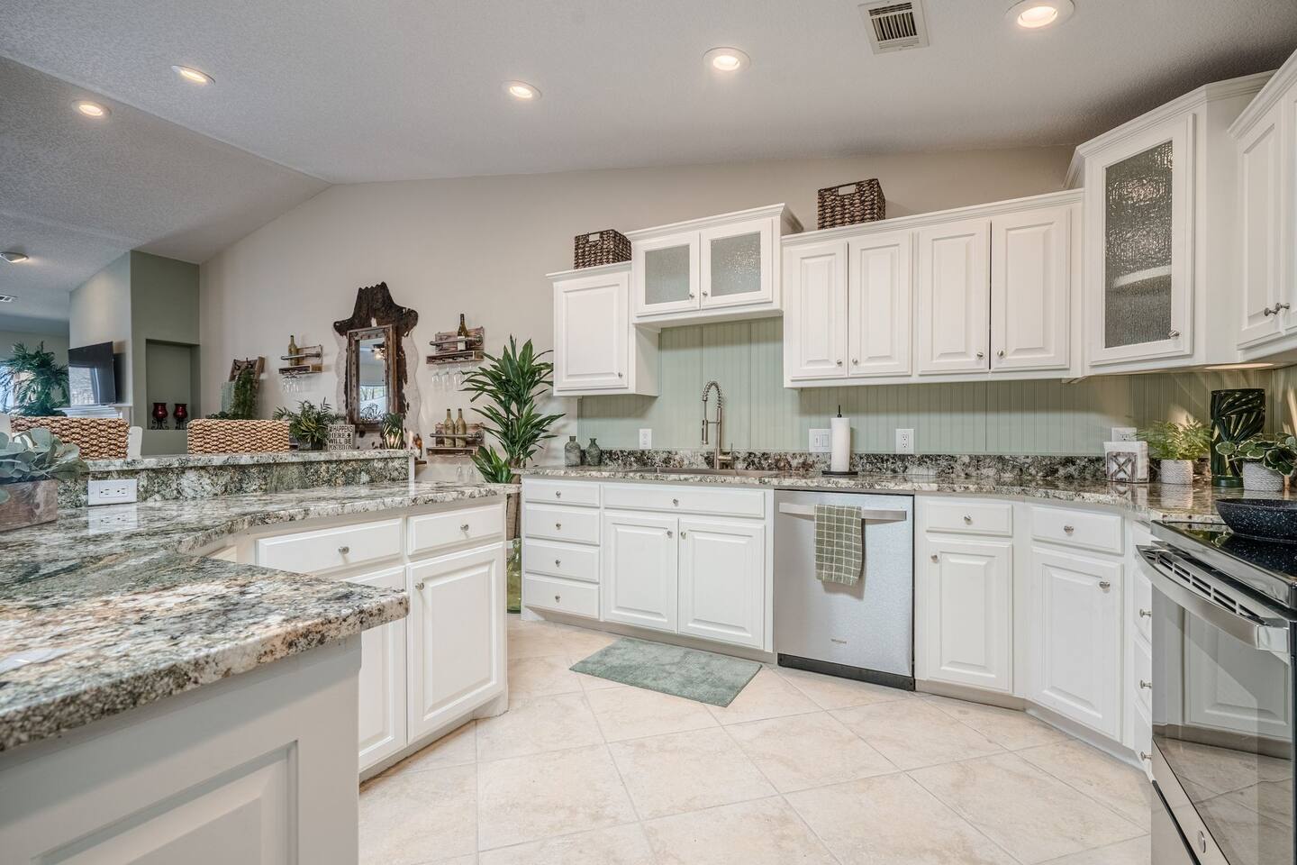 A kitchen with white cabinets and granite counter tops.