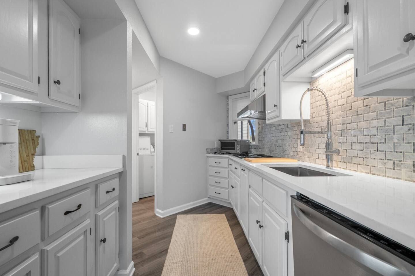 A kitchen with white cabinets and stainless steel appliances.