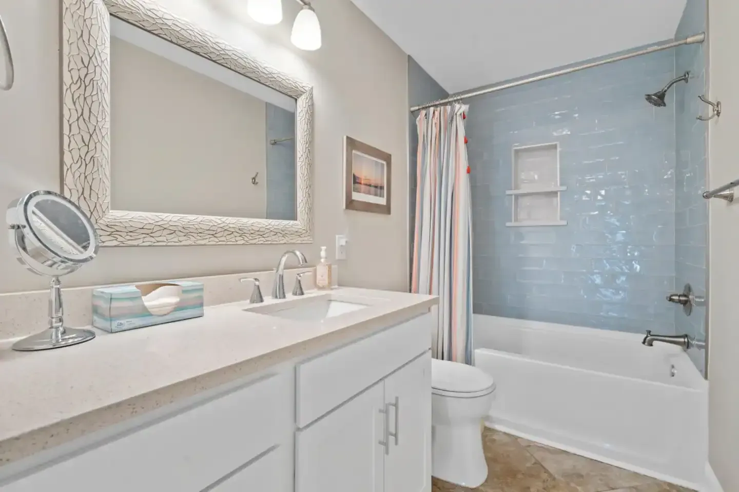 A bathroom with a sink , toilet , tub and mirror.