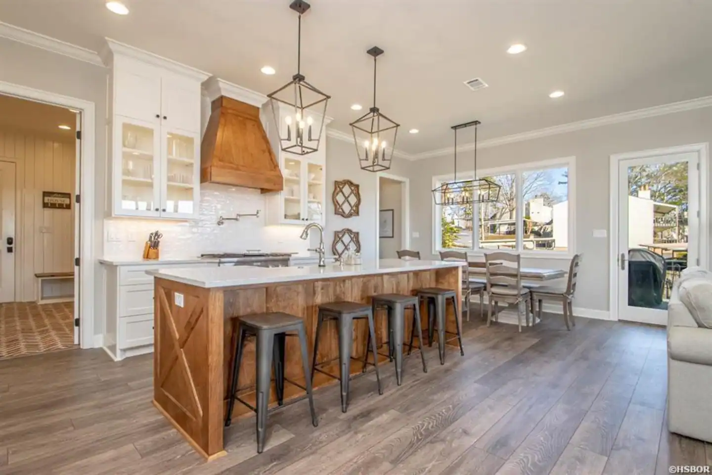 A kitchen with a large island and stools in a house.