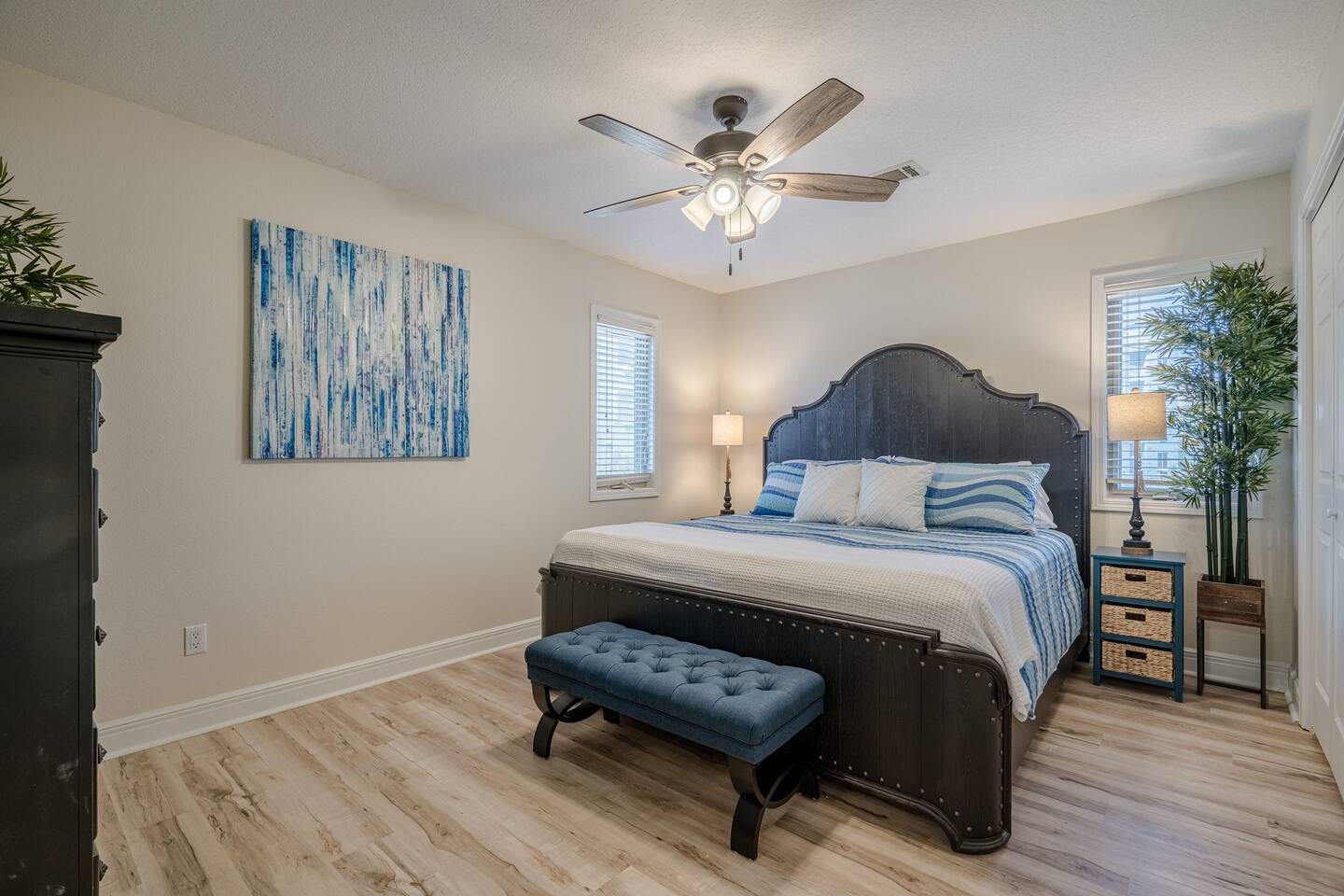 A bedroom with a king size bed and a ceiling fan.