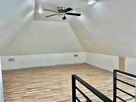There is a ceiling fan in the attic of a house.