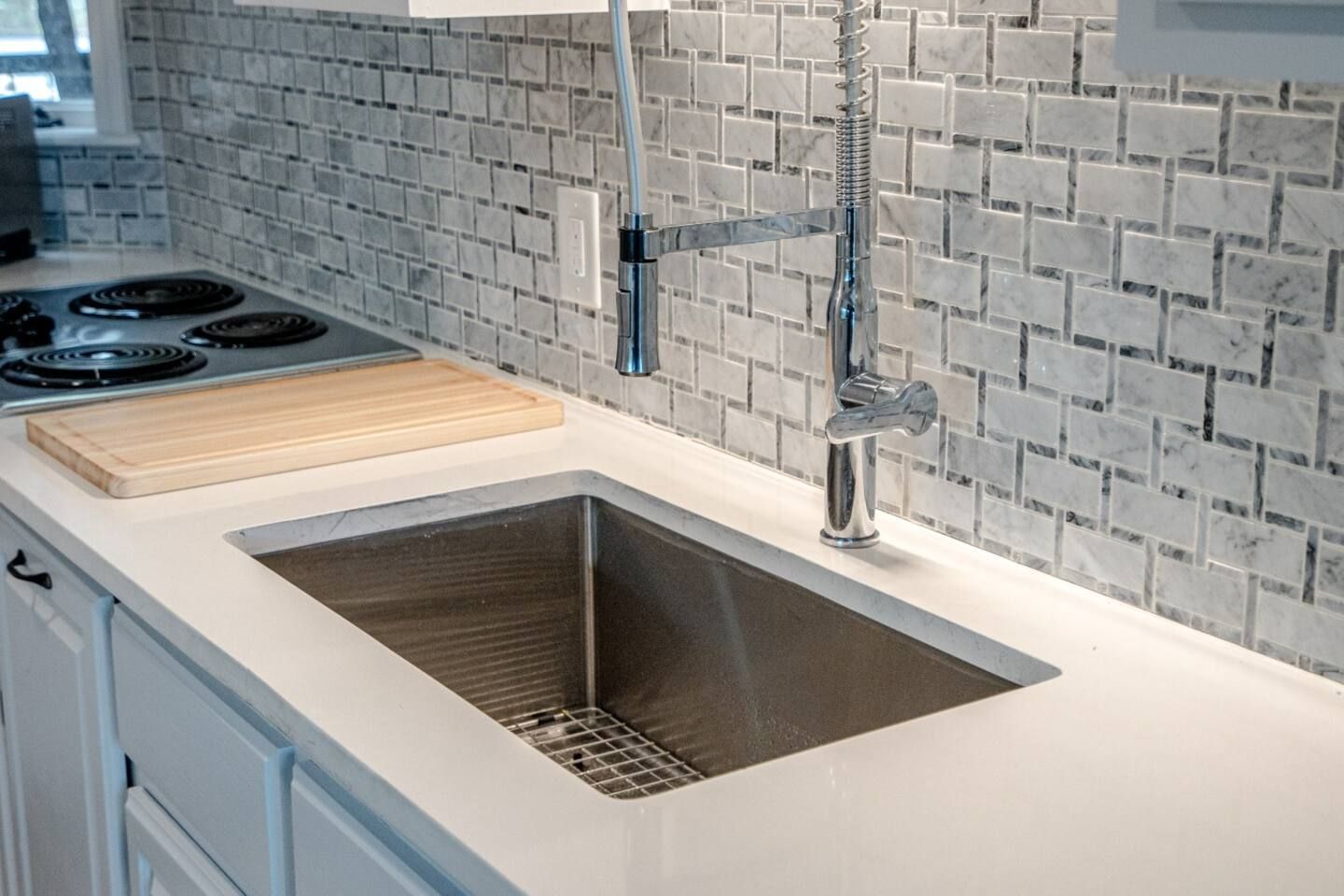 A kitchen with a stainless steel sink and a faucet.