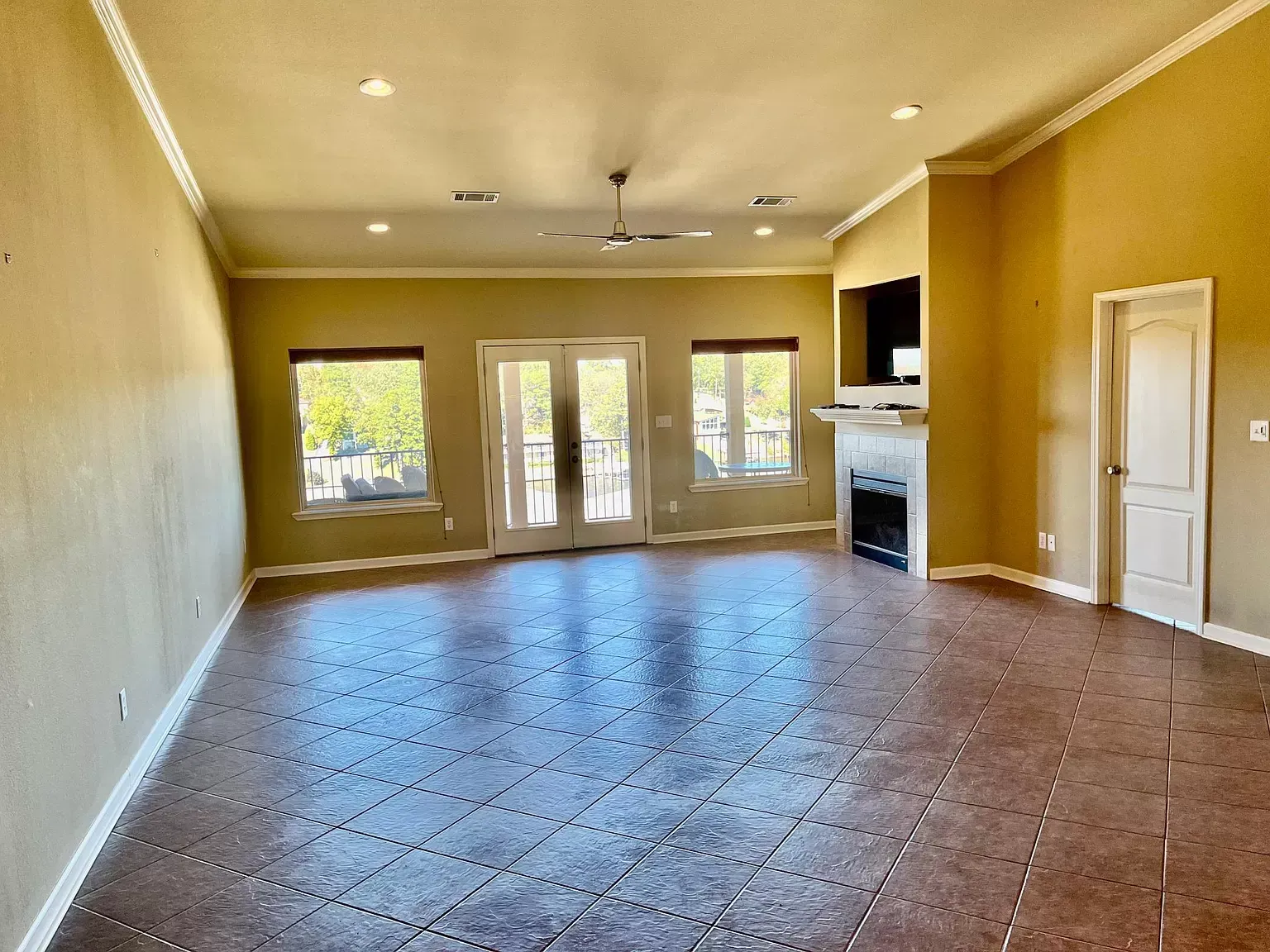 An empty living room with a fireplace and sliding glass doors