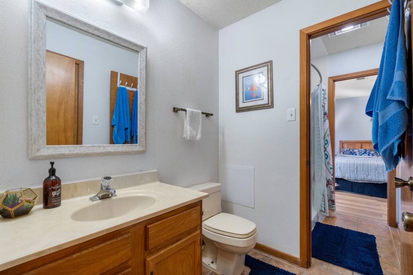 A bathroom with a sink , toilet and mirror.