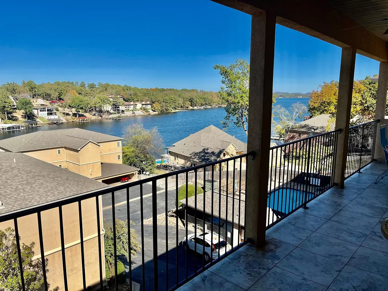 A balcony with a view of a lake and houses