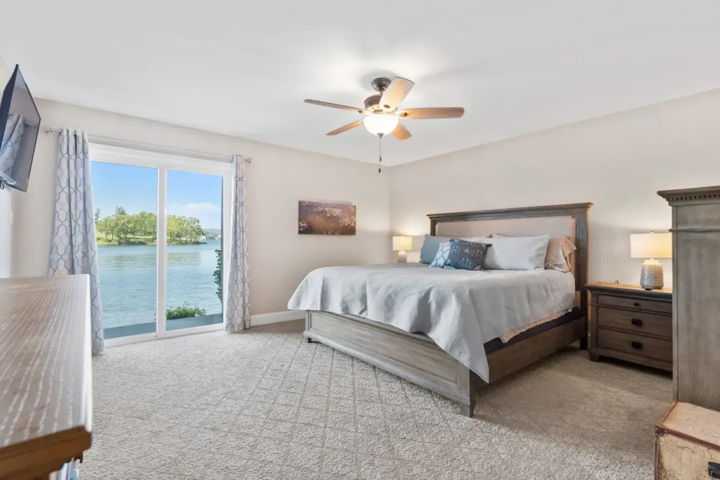 A bedroom with a king size bed and a ceiling fan.