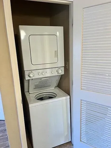 A washer and dryer are stacked on top of each other in a closet.
