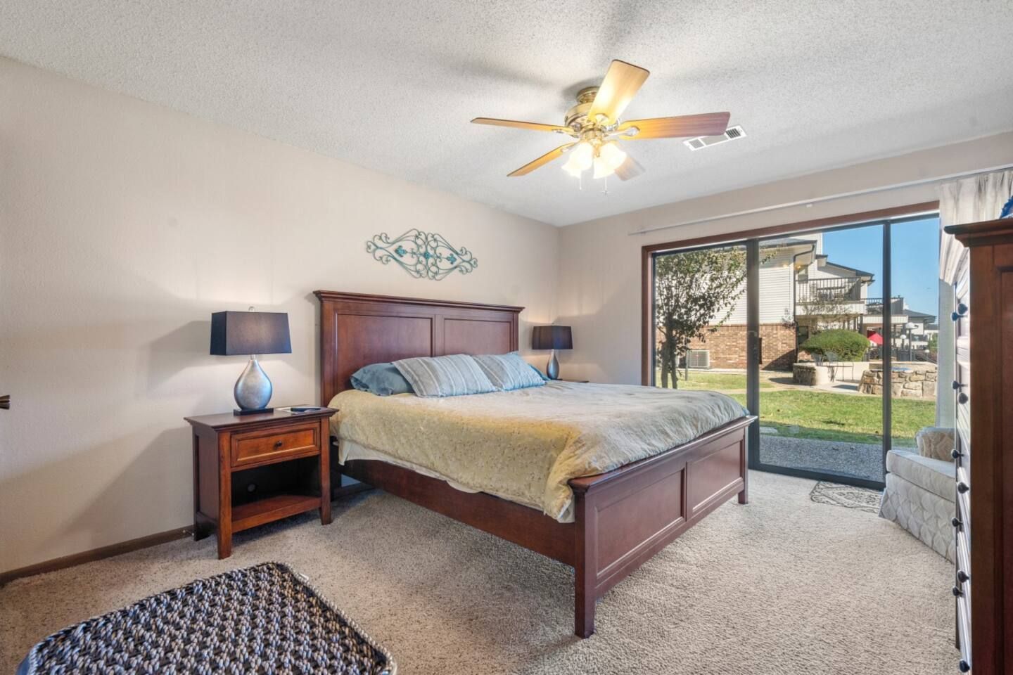 A bedroom with a king size bed and a ceiling fan.