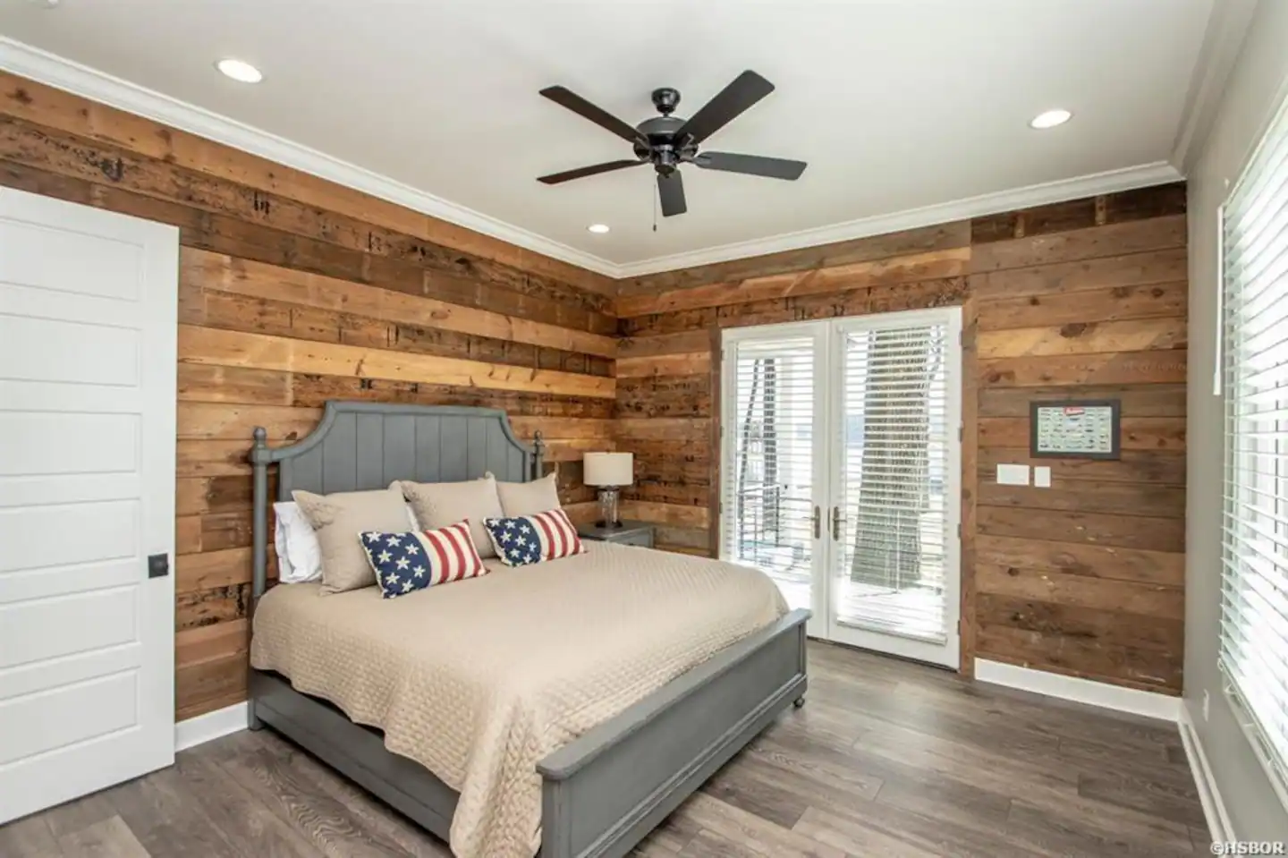 A bedroom with a king size bed and a ceiling fan.