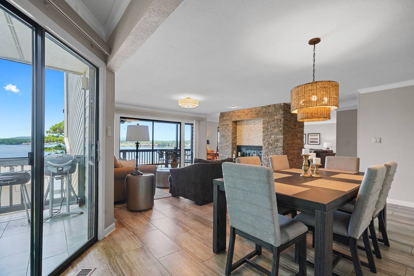 A living room with a dining table and chairs and a view of the water.
