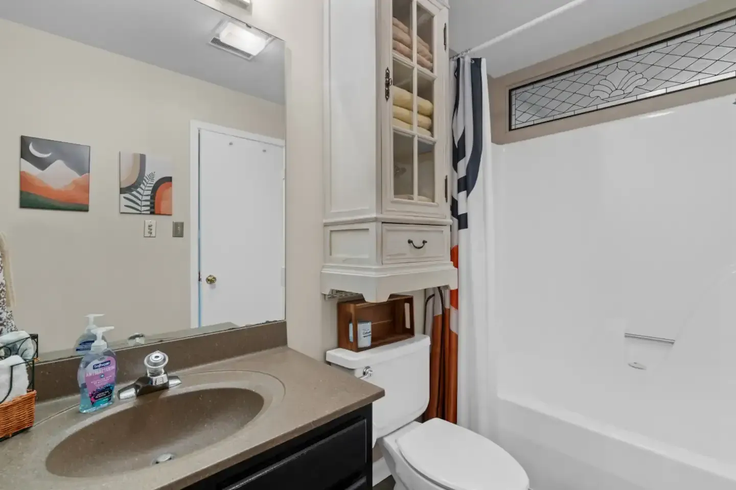 A bathroom with a sink , toilet , tub and mirror.