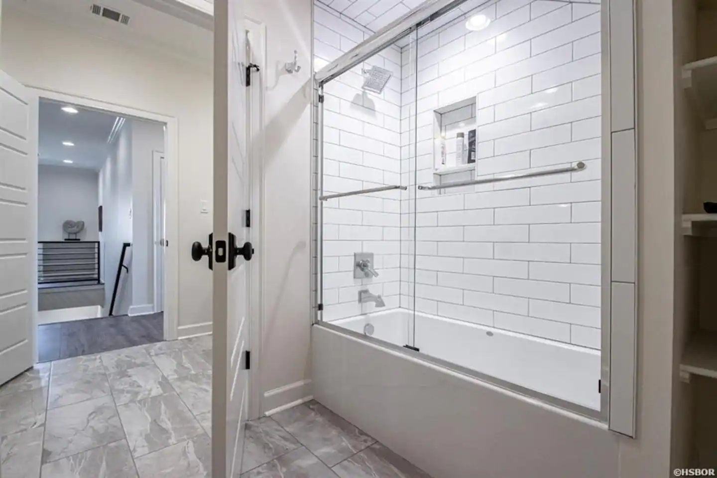 A bathroom with a bathtub , shower , and sliding glass door.