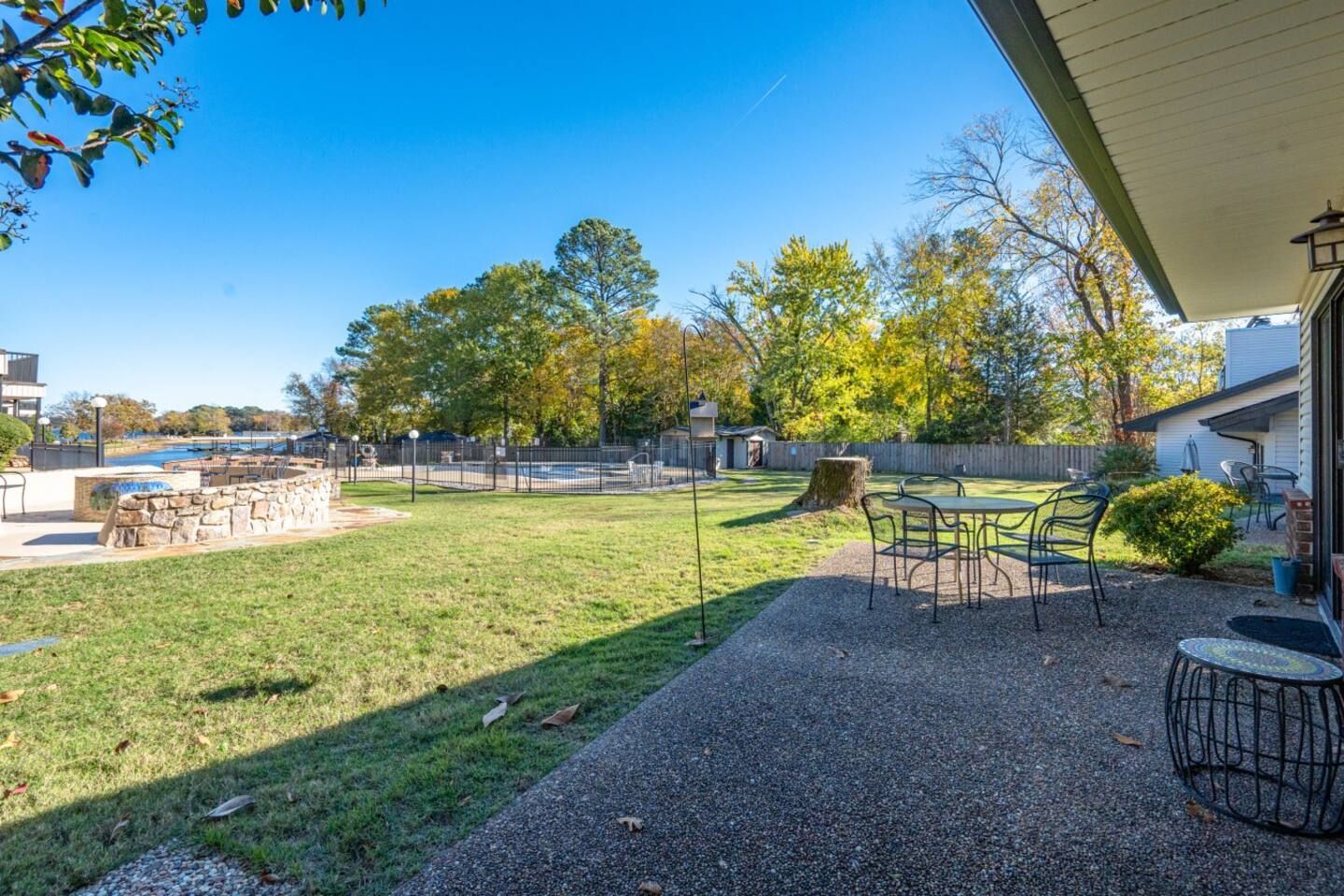A patio with a table and chairs in the backyard of a house.