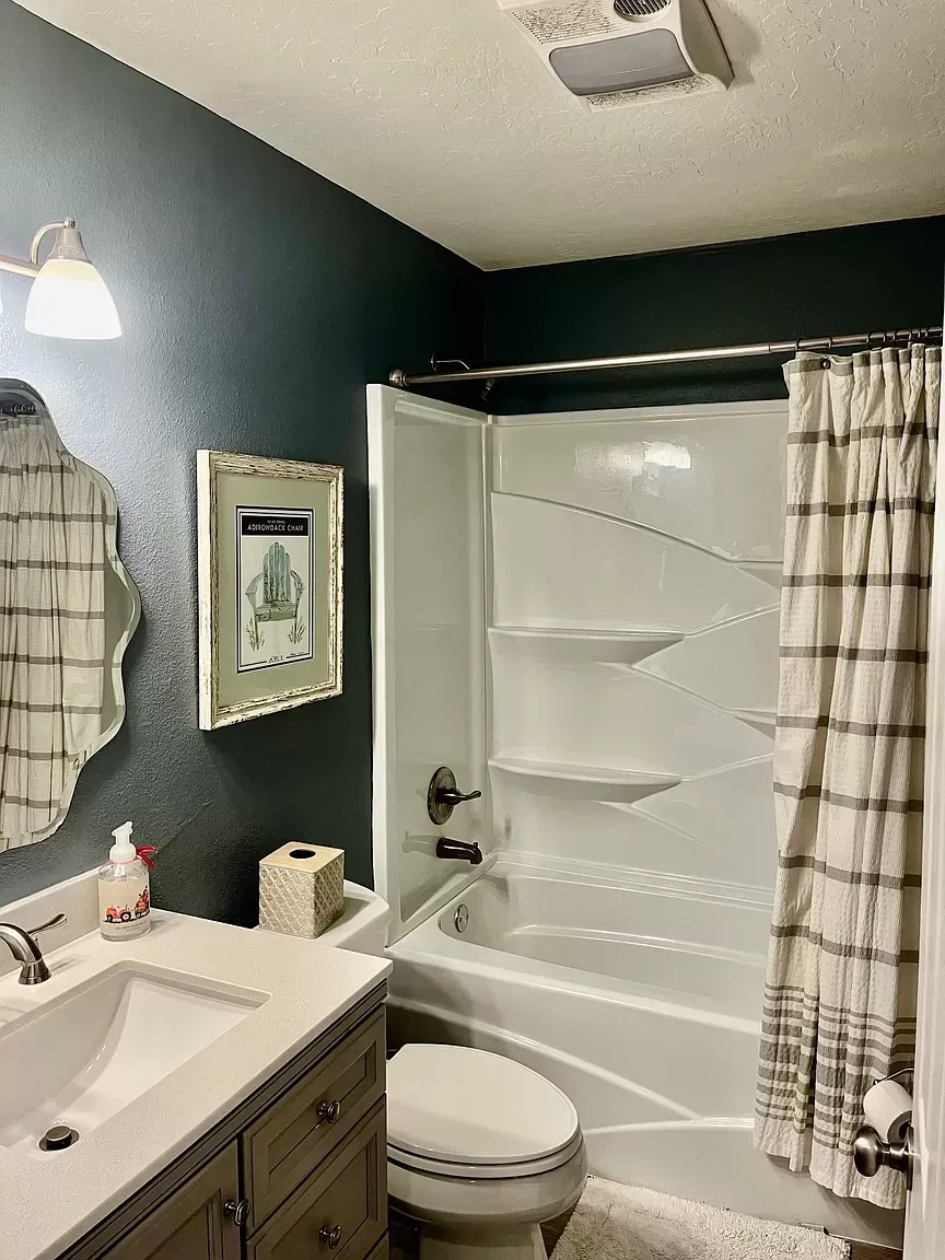 A bathroom with a sink , toilet , bathtub and mirror.