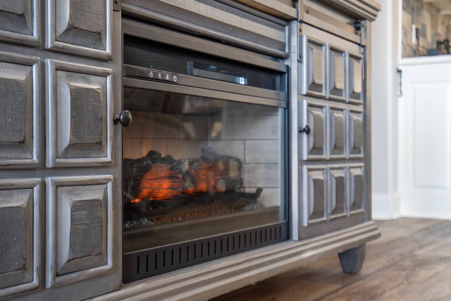 A fireplace is sitting on top of a wooden entertainment center in a living room.