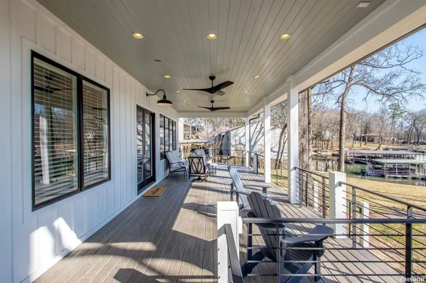 A large porch with chairs and a ceiling fan.
