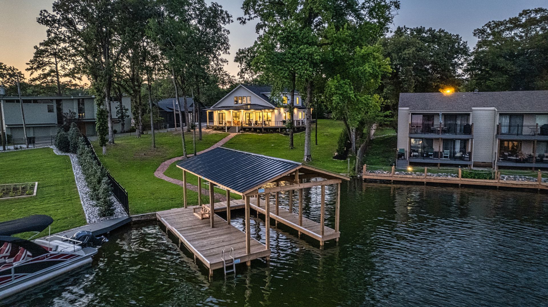 An aerial view of a house and dock on a lake.