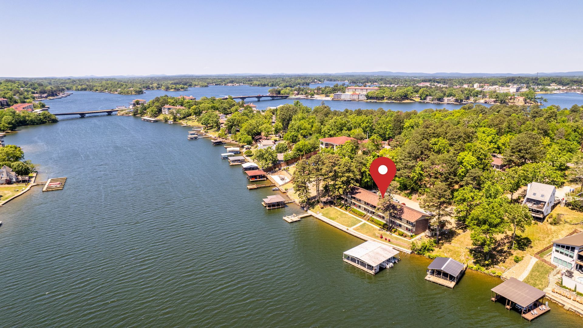 An aerial view of a lake with a house in the middle of it.