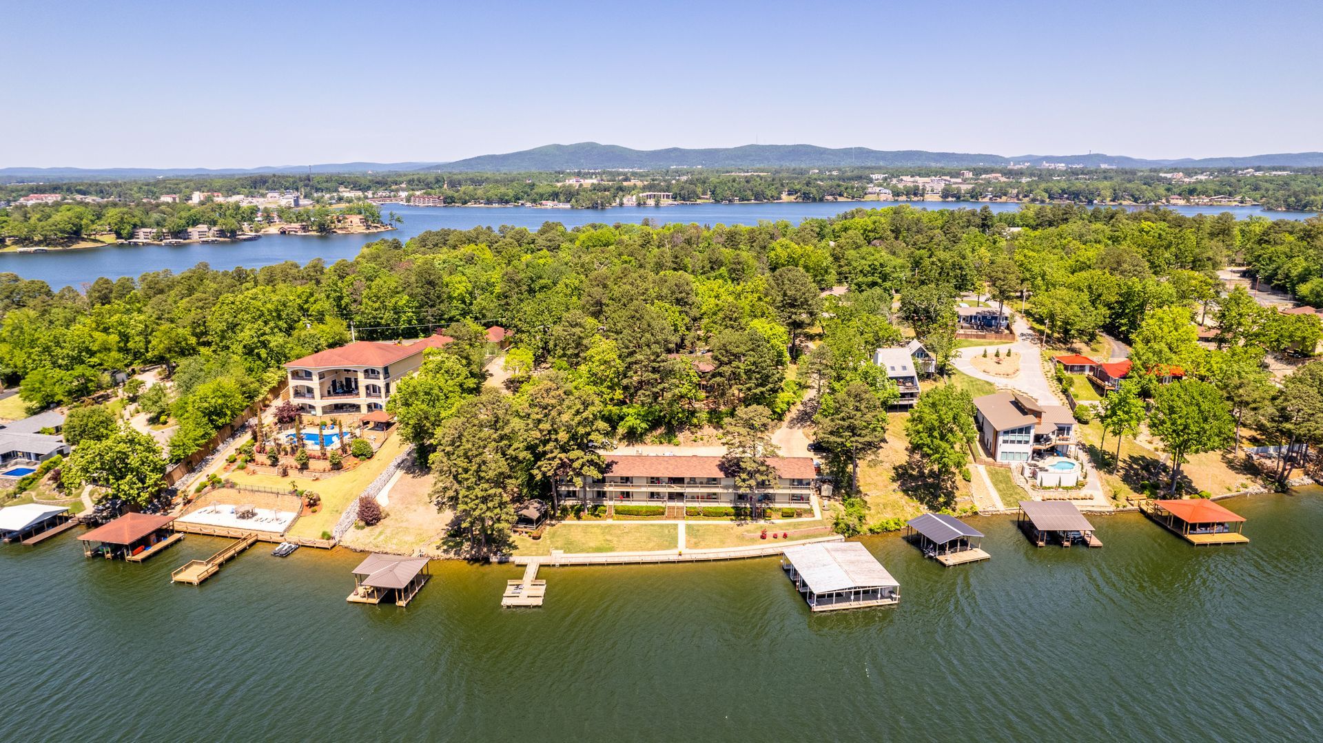An aerial view of a lake surrounded by trees and houses.