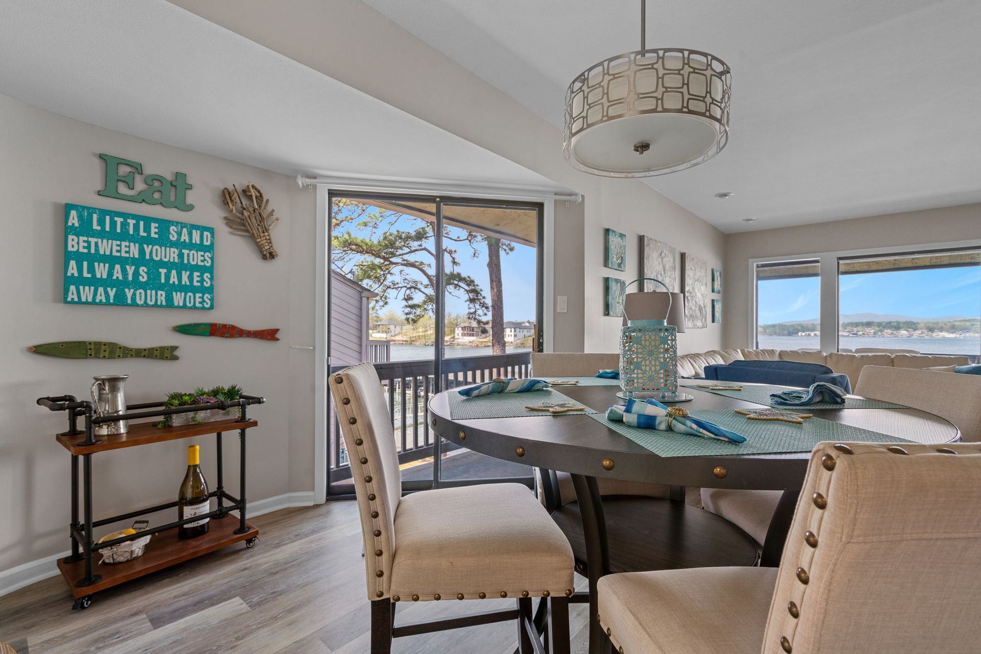 A dining room with a table and chairs and a bar cart.