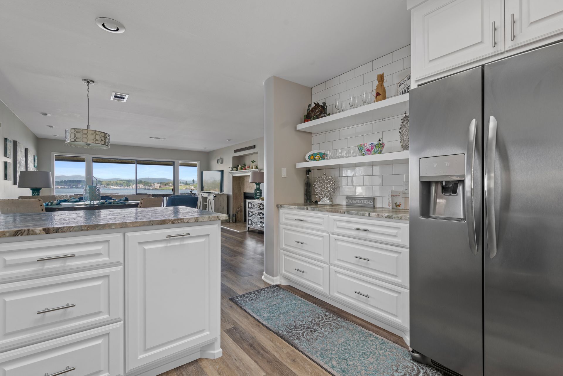 A kitchen with white cabinets and a stainless steel refrigerator.