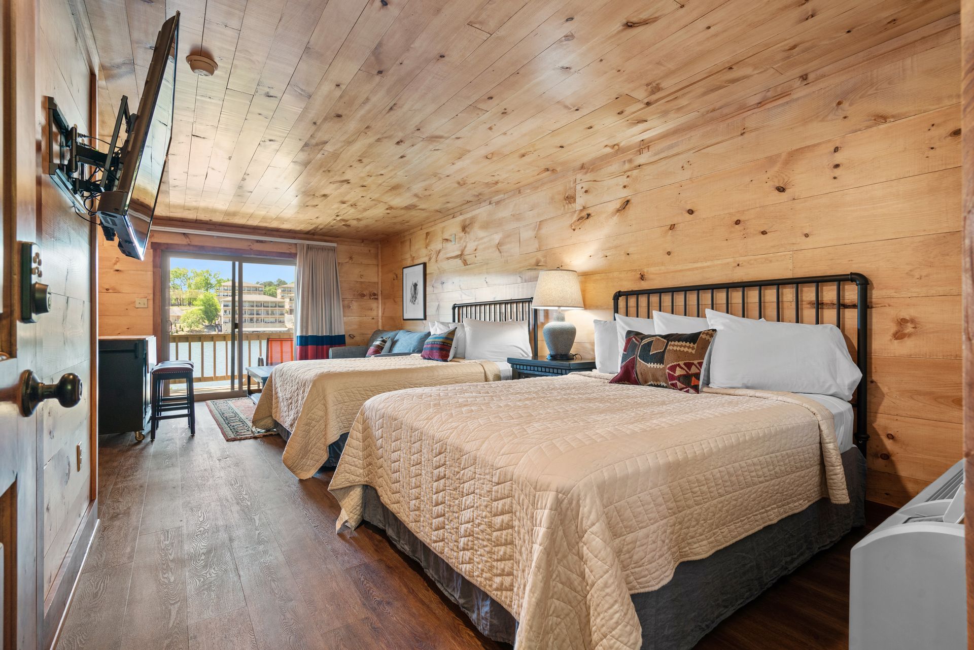 A hotel room with two beds and a flat screen tv.