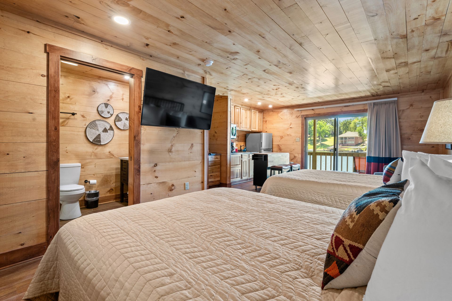 A hotel room with two beds and a flat screen tv.