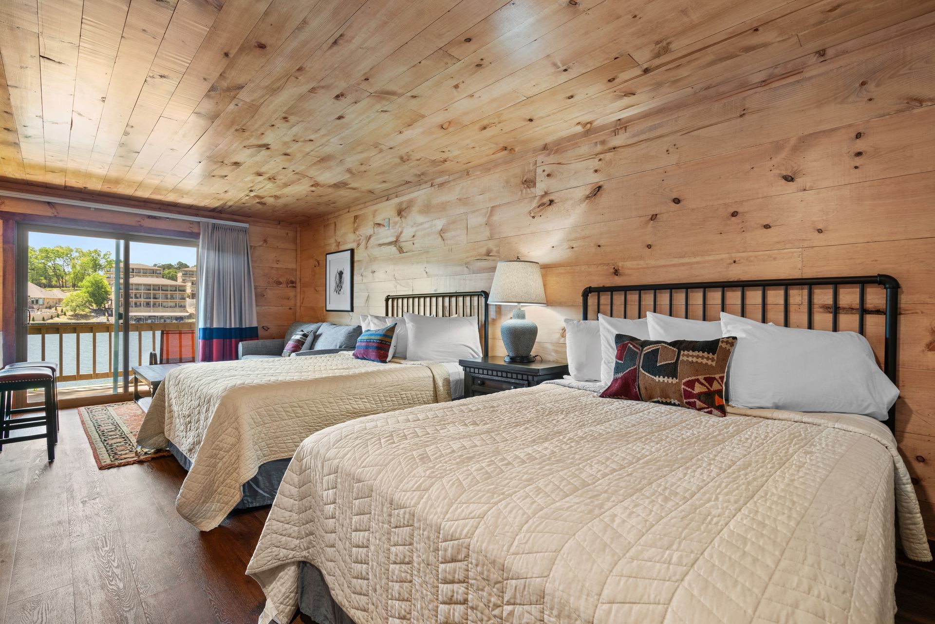 A hotel room with two beds and a balcony.