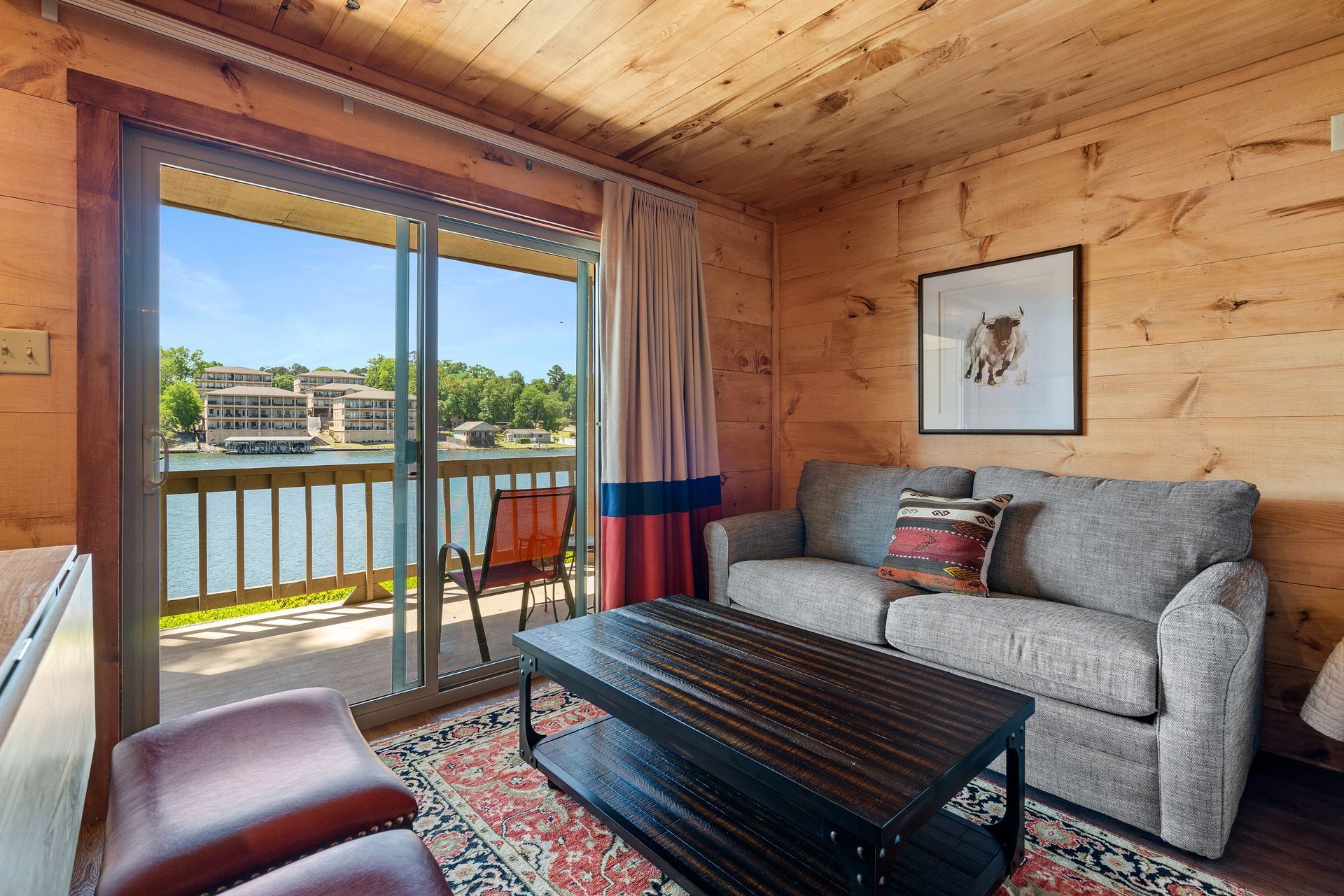 A living room with a couch and a coffee table with a view of a lake.