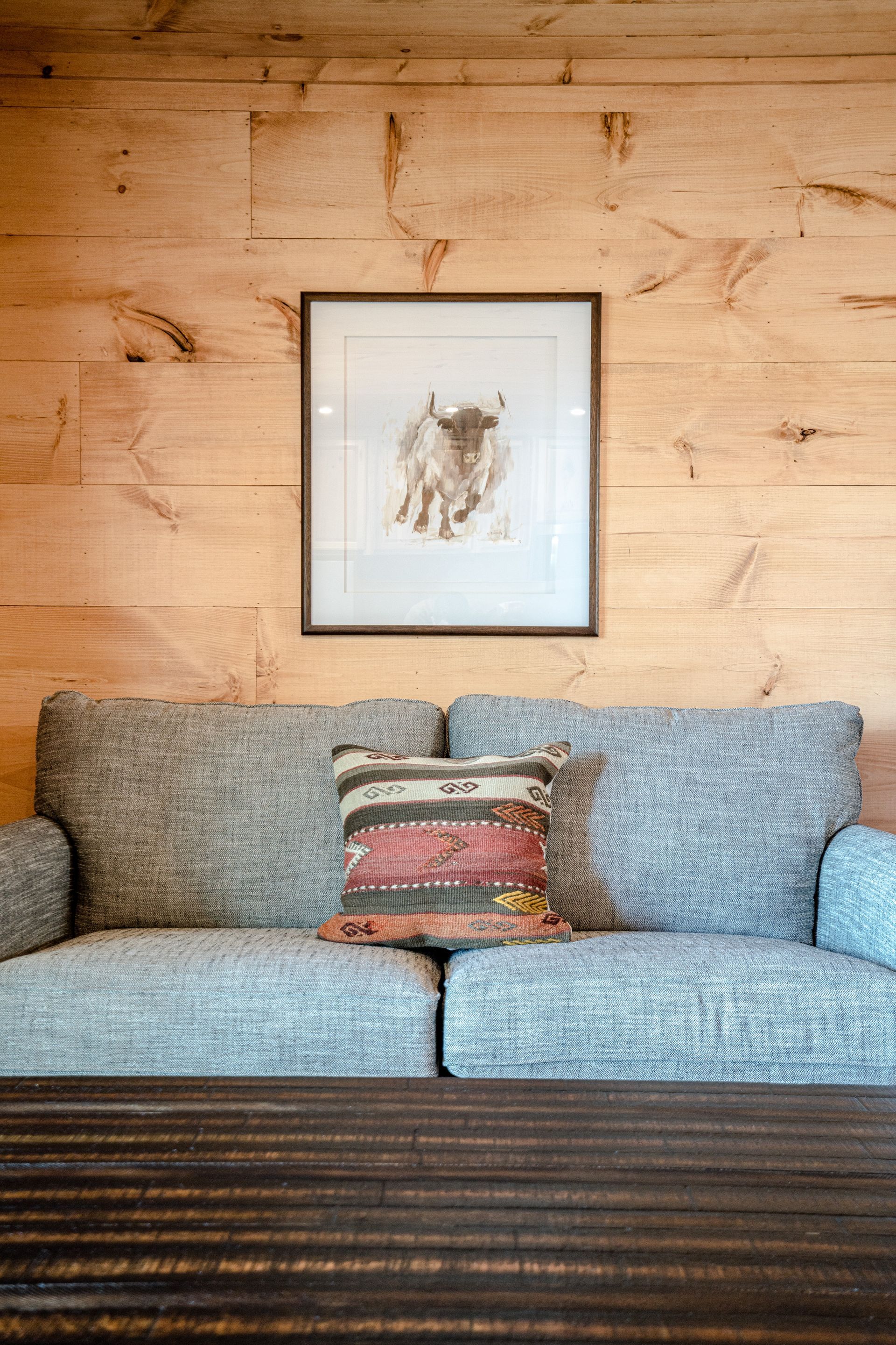 There is a picture of a bull on the wall above the couch.