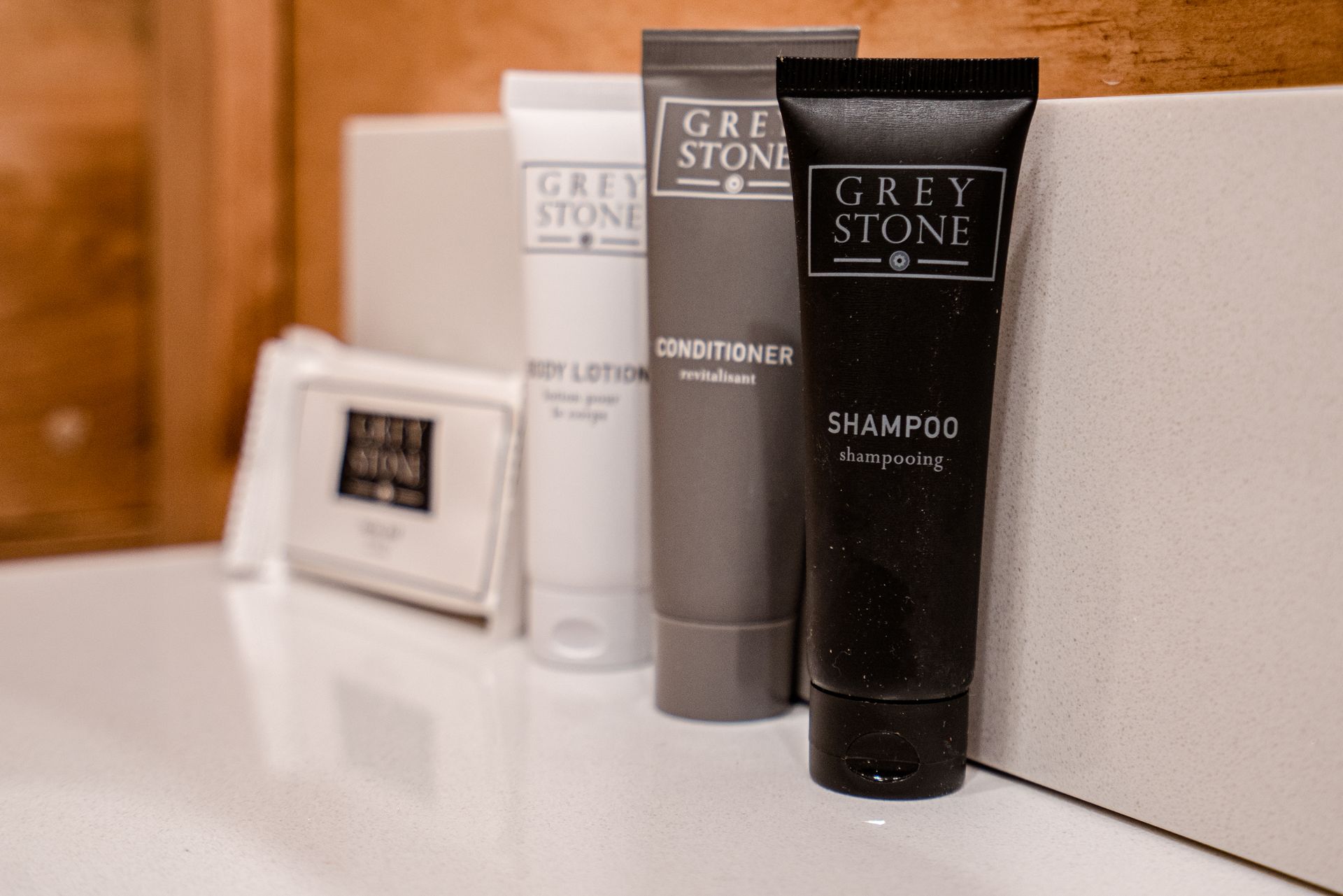 A bottle of grey stone shampoo is sitting on a bathroom counter.