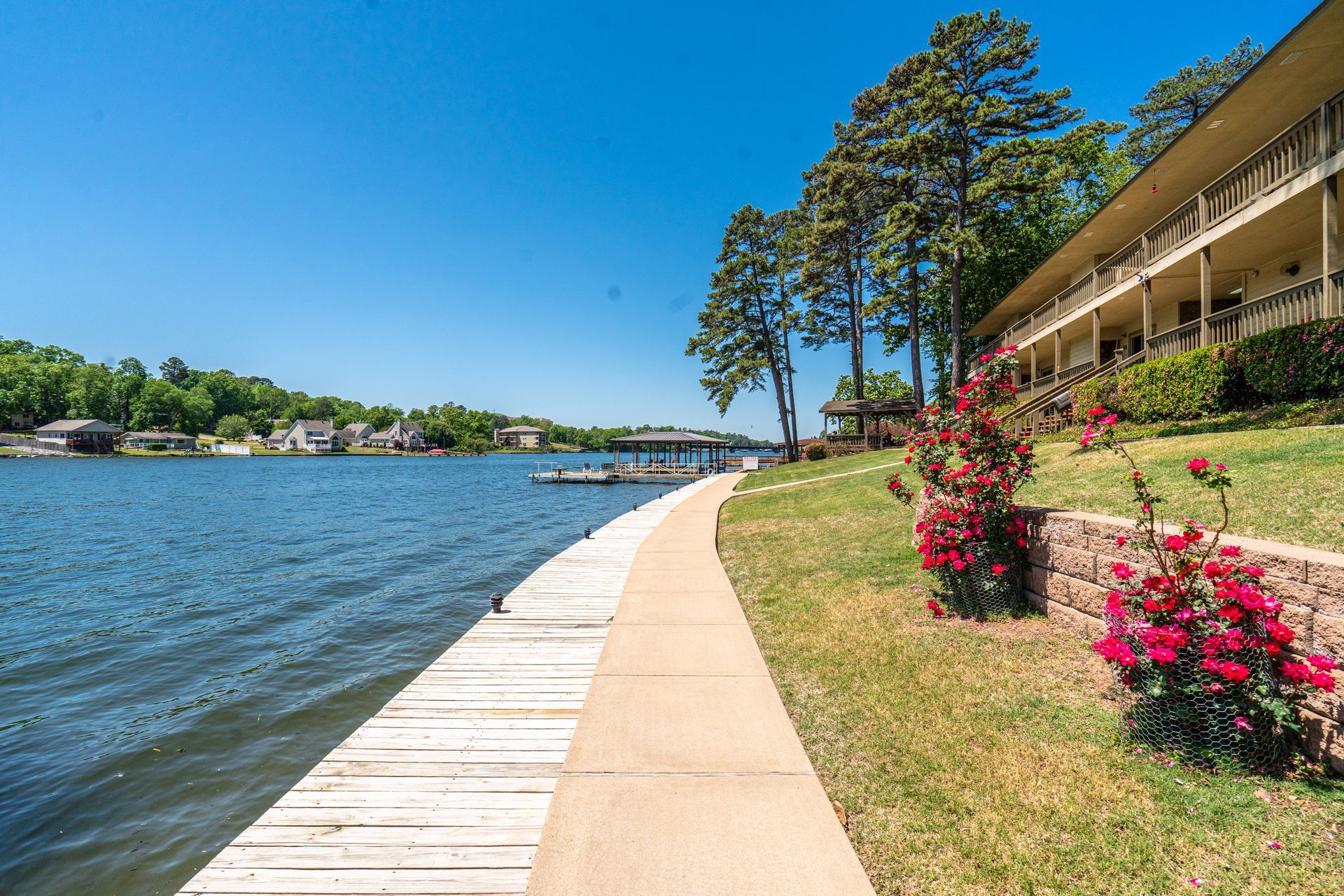 A walkway leading to a lake with a large building in the background.