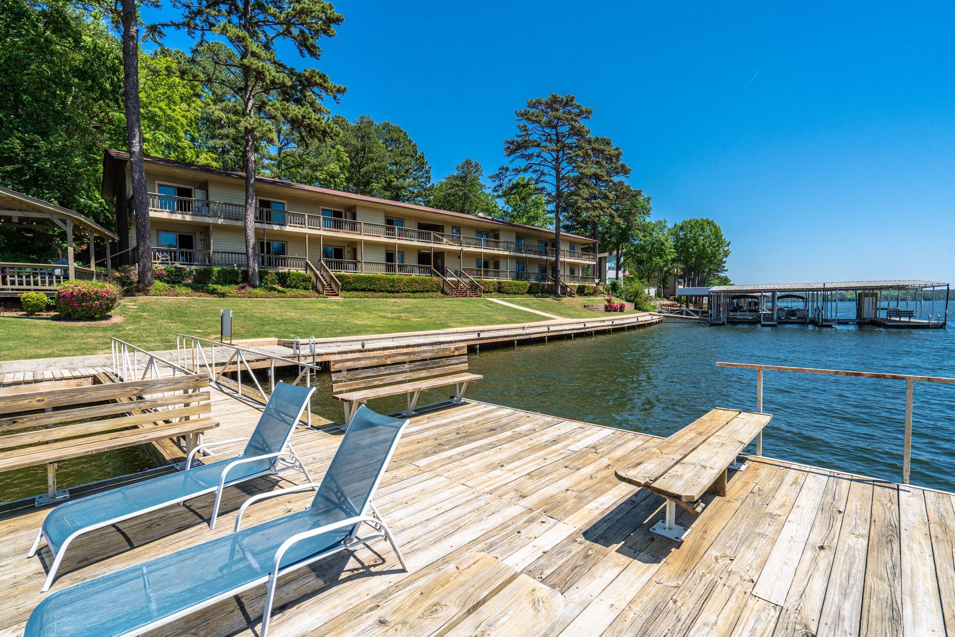 A dock with chairs and a picnic table next to a body of water.