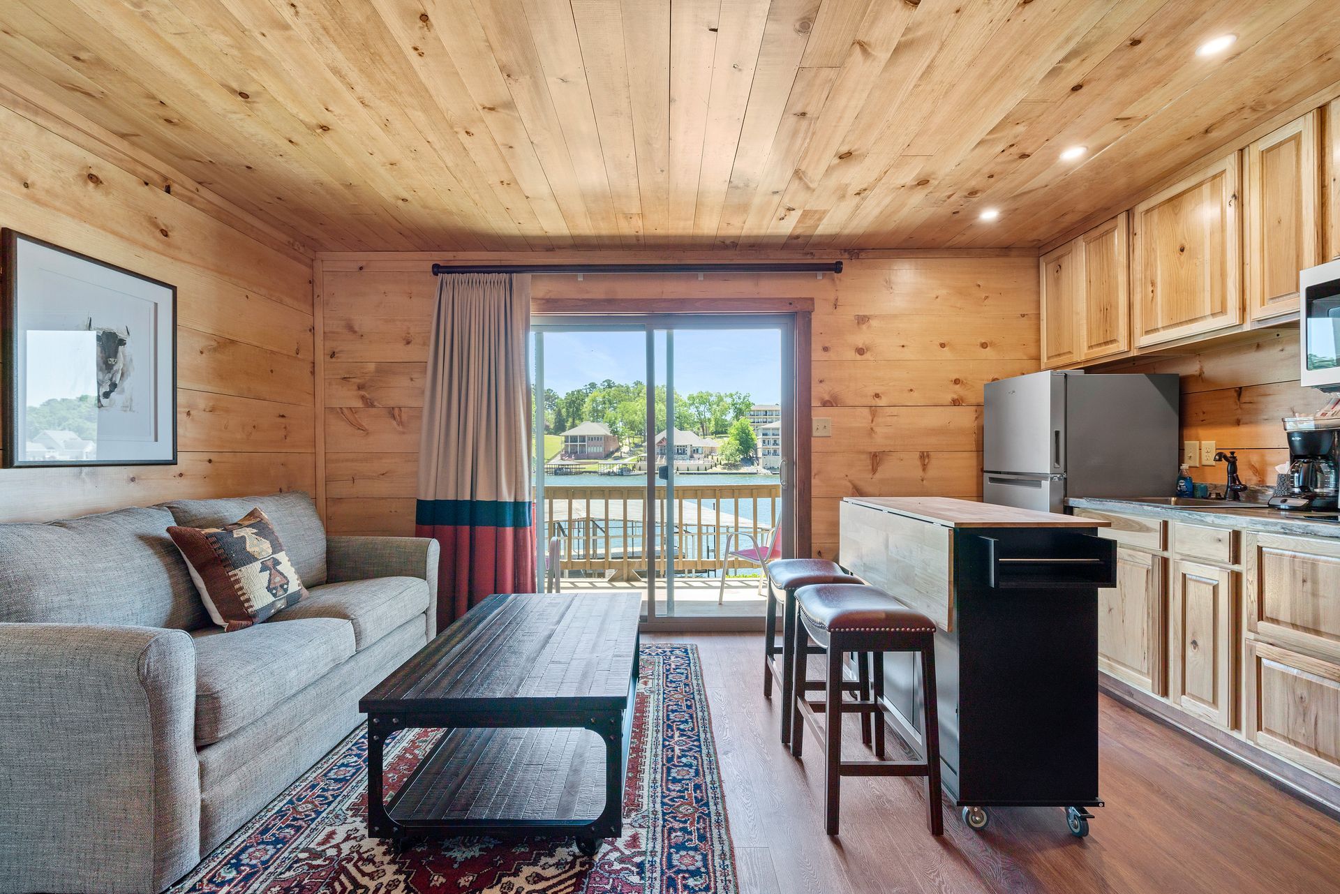 A living room with a couch , coffee table , and sliding glass doors leading to a balcony.