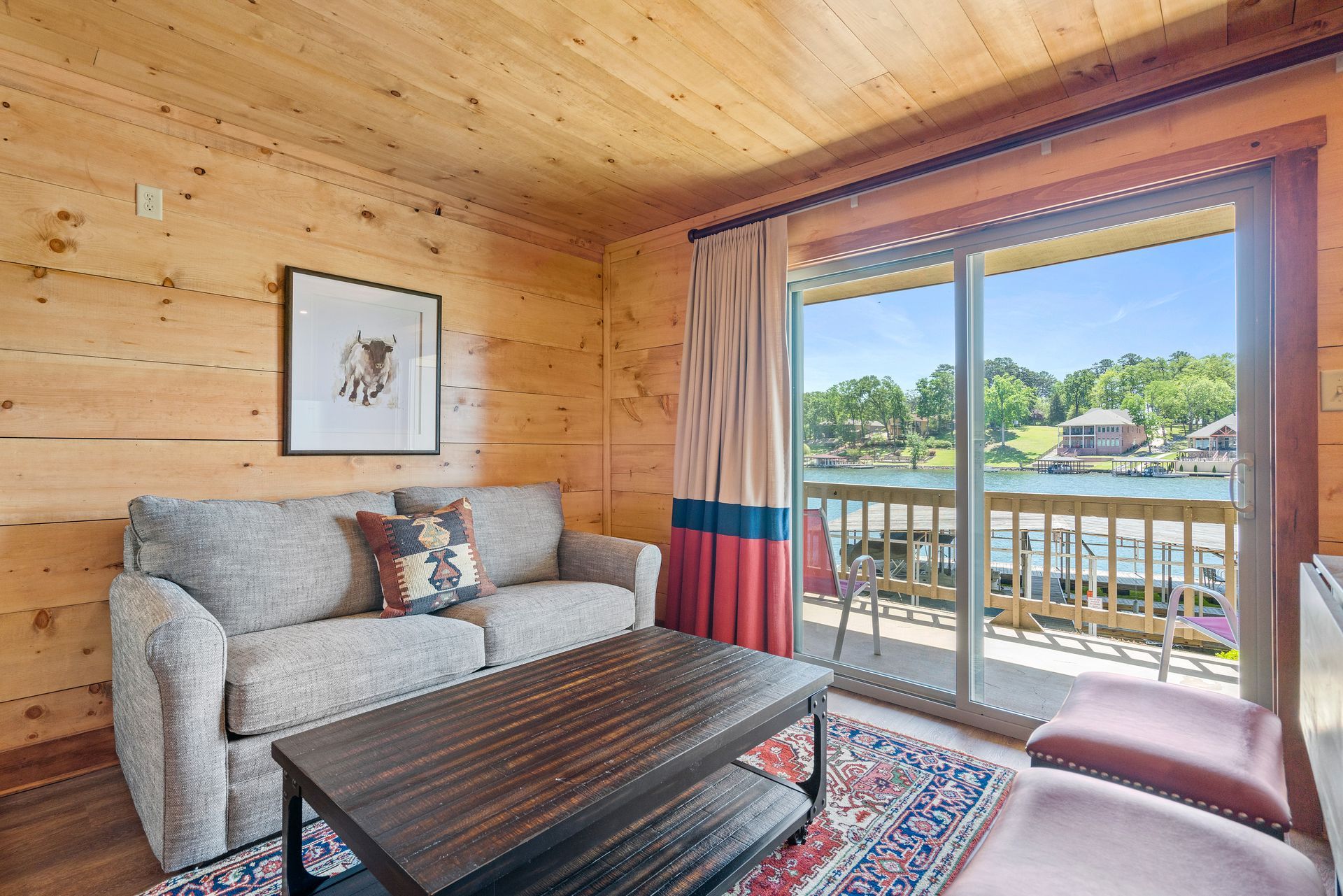 A living room with a couch , coffee table , chairs and a balcony.