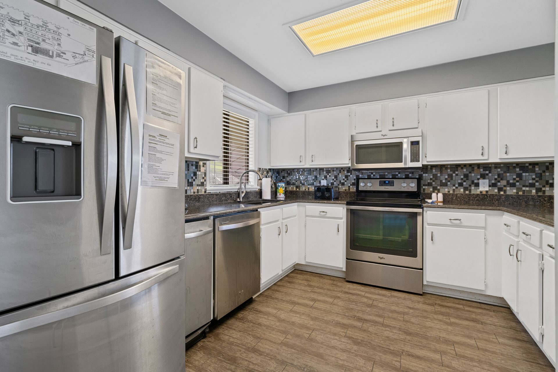 A kitchen with stainless steel appliances and white cabinets.